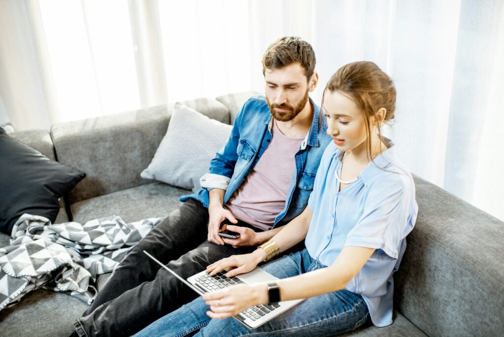 Couple sitting with laptop at home